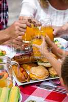 Midsection of family toasting drinks while having lunch
