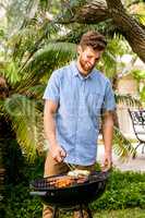 Happy man preparing food on barbecue grill