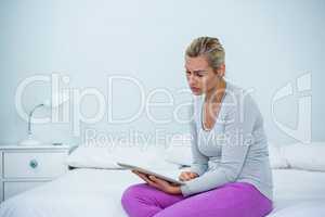 Young woman with digital tablet on bed