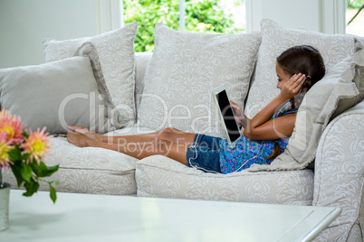 Girl listening music while relaxing on sofa