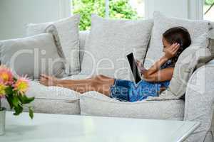 Girl listening music while relaxing on sofa