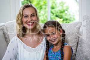 Cheerful mother with daughter on sofa