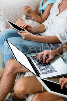 Cropped image of family using various technologies