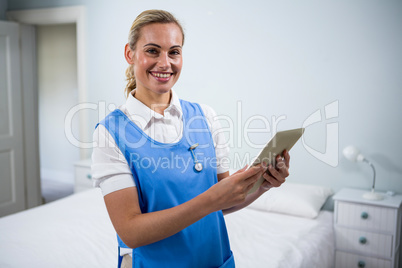 Portrait of confident nurse holding digital tablet