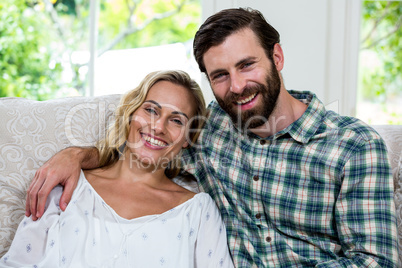 Portrait of cheerful young couple on sofa