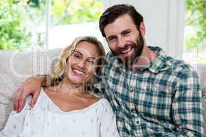 Portrait of cheerful young couple on sofa