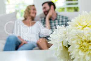 Close-up of dahlias on table against romantic couple