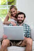 Happy couple with laptop in living room