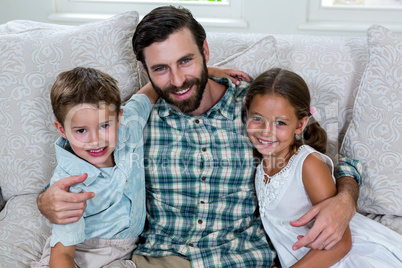 Portrait of father with children on sofa
