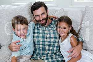 Portrait of father with children on sofa