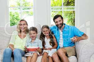 Portrait of happy family laughing while watching tv
