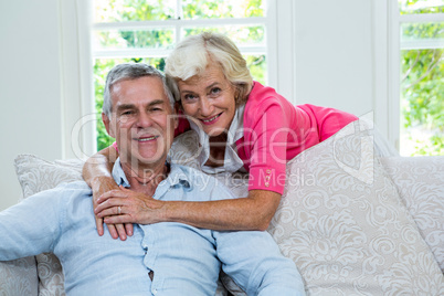 Portrait of senior woman embracing husband from behind