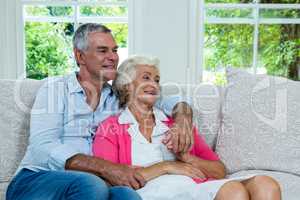 Senior couple looking away at home