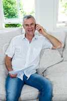 Portrait of senior man talking on mobile phone while sitting on