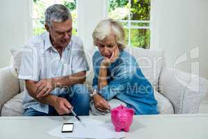 Senior man discussing with wife regarding savings on sofa