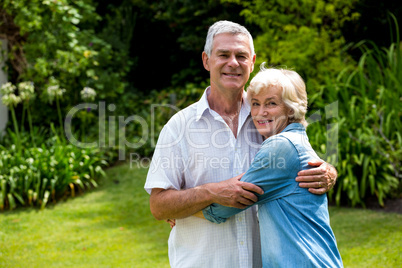 Portrait of senior couple embracing in back yard