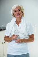 Portrait of active senior woman standing with water bottle