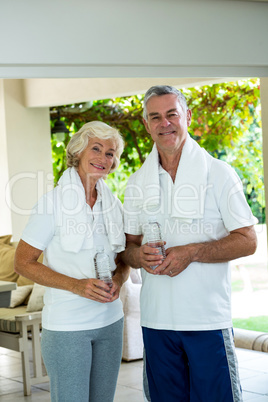 Happy senior couple holding water bottles