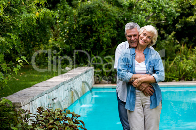 Loving senior man embracing wife from behind while standing at p