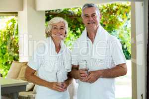 Portrait of active senior couple holding water bottles
