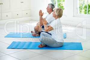 Senior couple meditating on exercise mat