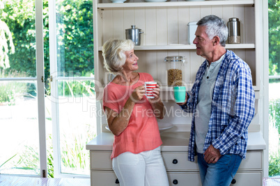 Happy senior couple having coffee at home