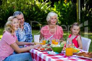 Happy family having meal in yard