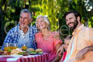 Happy family enjoying while having meal in yard