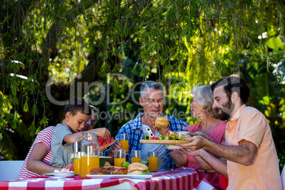 Happy family enjoying while having food in yard