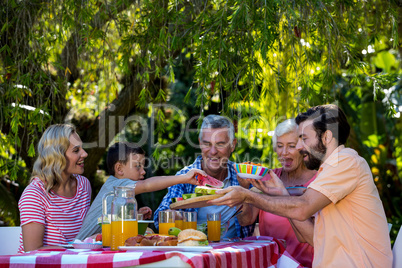 Happy family enjoying while having meal in yard