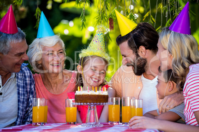 Family celebrating birthday of girl at yard