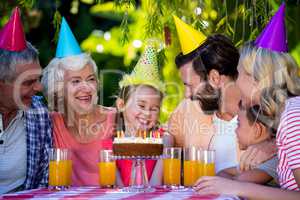 Family celebrating birthday of girl at yard