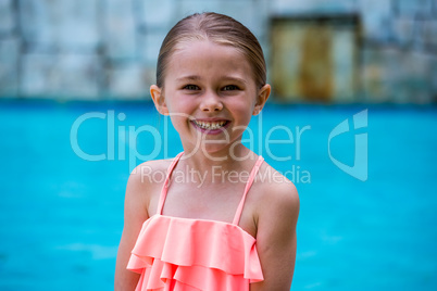 Portrait of girl standing by swimming pool