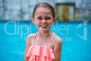 Portrait of girl standing by swimming pool