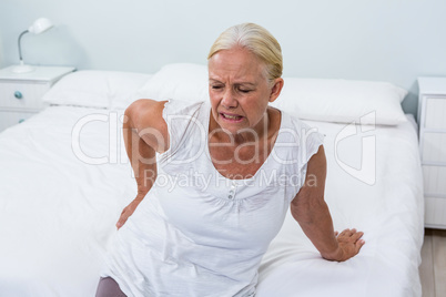 Senior woman suffering from back pain at home