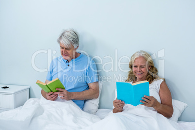 Smiling senior couple reading book