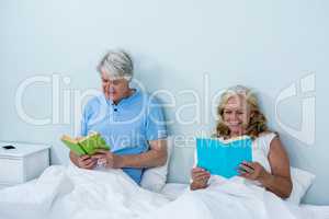 Smiling senior couple reading book