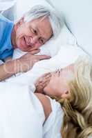 Romantic senior couple sleeping on bed
