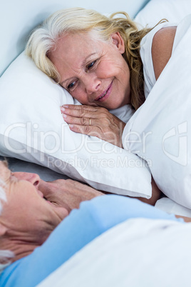 Cheerful senior couple sleeping on bed