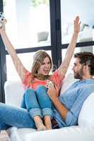 Happy woman with man playing video game at home