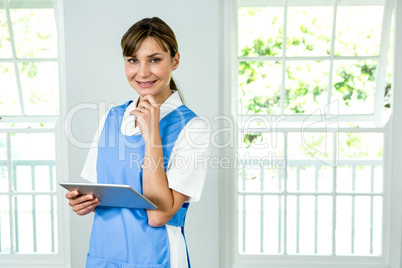 Portrait of smiling nurse holding digital tablet