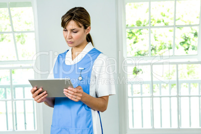 Focused nurse using digital tablet