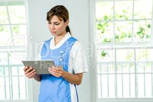 Focused nurse using digital tablet