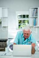 Senior man doing online shopping by using laptop