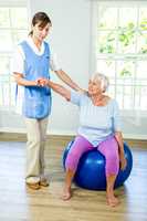 Senior woman exercising with nurse