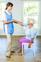 Senior woman stretching hand with nurse