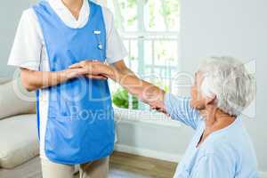 Midsection of nurse assisting senior woman