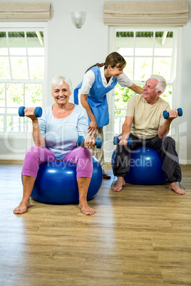 Senior man and woman holding dumbbellls