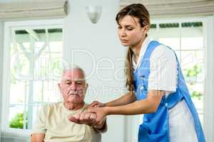 Focused nurse assisting senior man