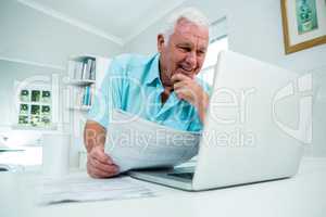 Smiling senior man looking into laptop